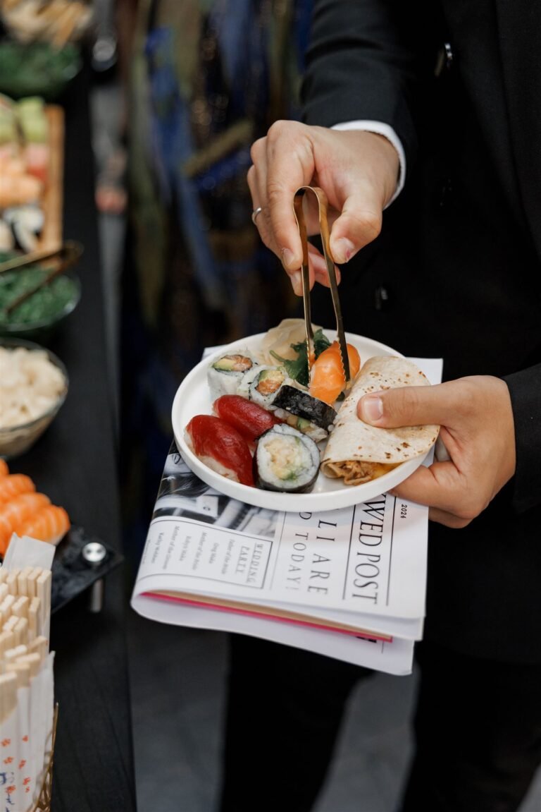 Guest holds a plate of sushi from the cocktail hour station