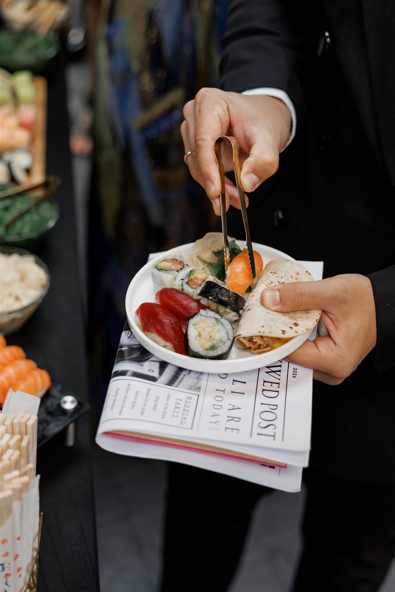 Guest holds a plate of sushi from the cocktail hour station