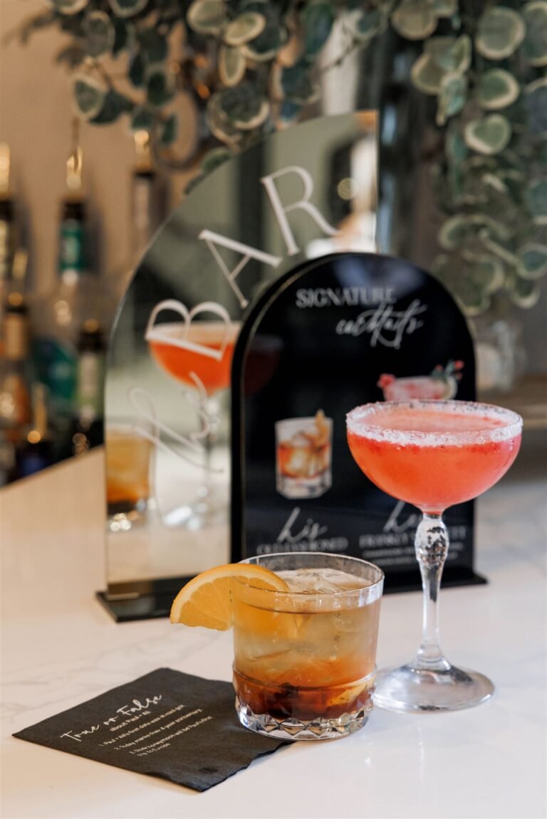 Signature cocktails displayed beside a custom menu sign at the bar