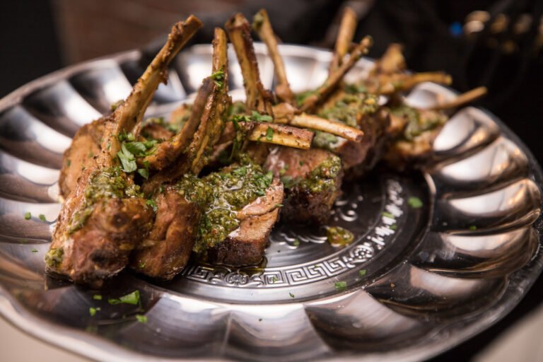 Herb-crusted lamb chops served on a silver platter