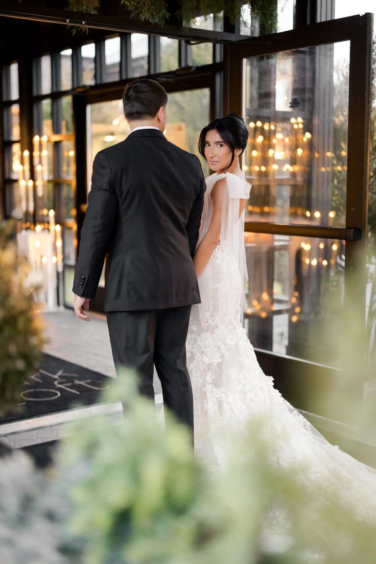 Bride and groom look out through the atrium windows at Park Loft