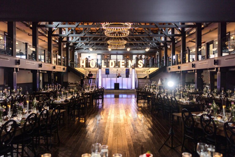 Park Loft dance hall set for a wedding reception, with candlelit tables, a polished dance floor and illuminated marquee letters