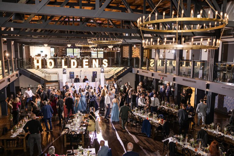 Guests fill the dance floor beneath ring chandeliers during a wedding reception at Park Loft