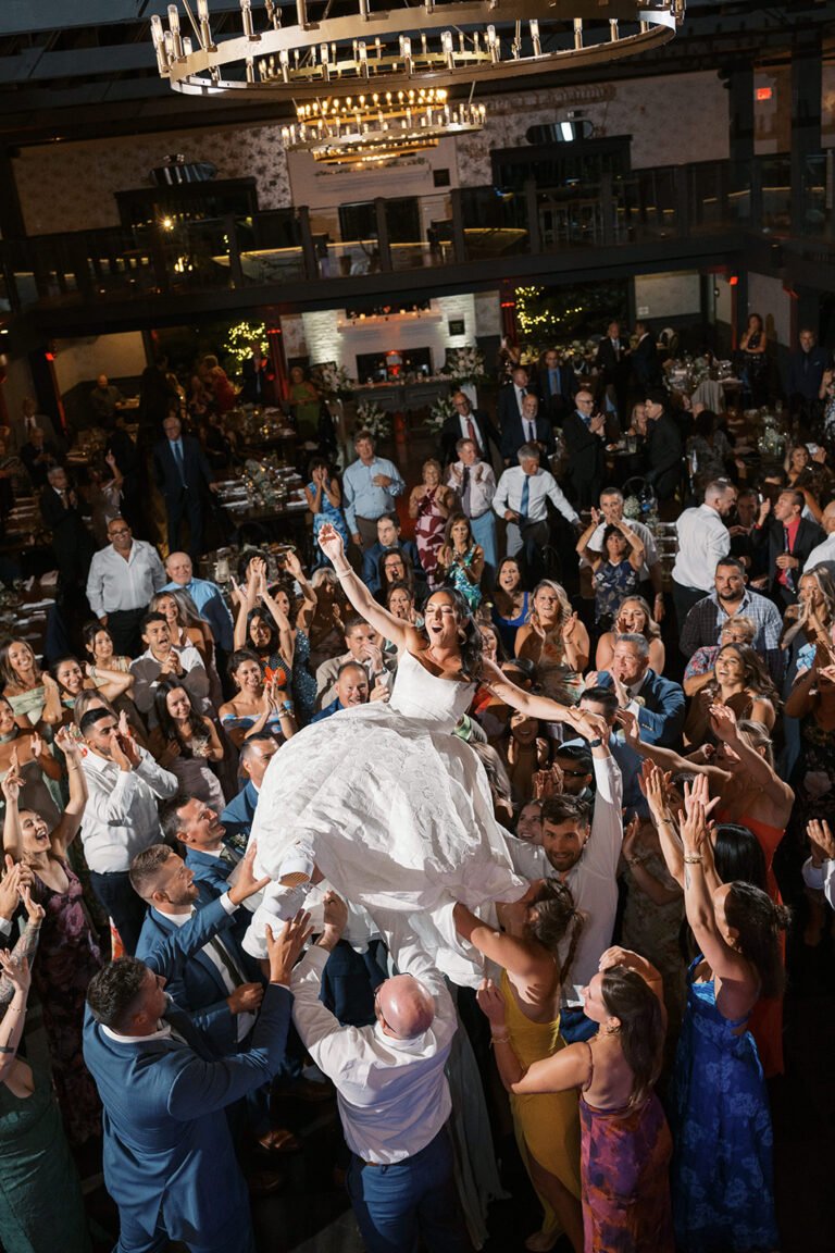 Guests lift the bride above a packed dance floor at a Park Loft wedding reception