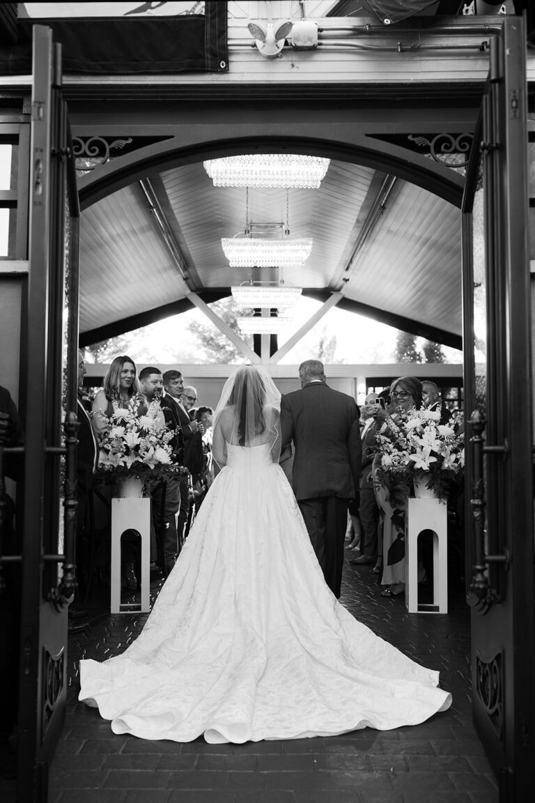 Black-and-white photo of a bride walking down the aisle with her father at Park Loft