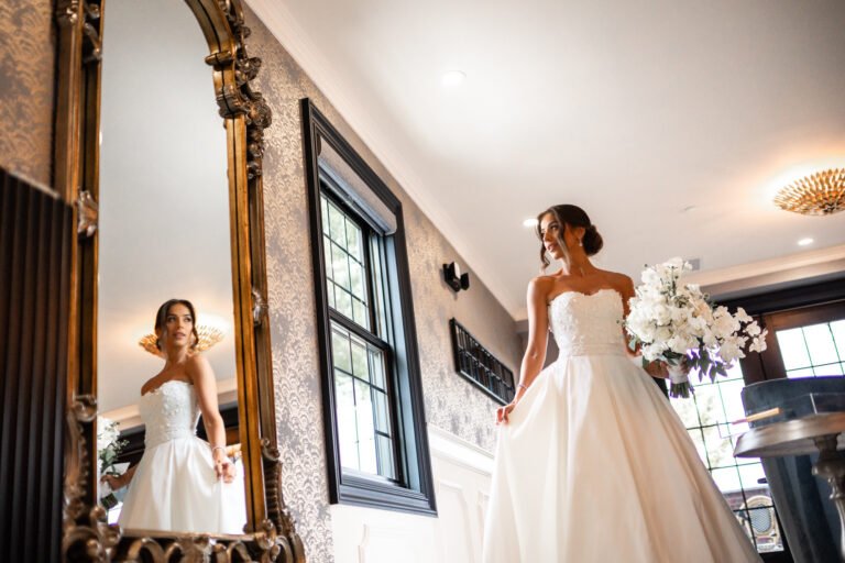 Bride admires her ballgown in a gilded mirror in the Park Loft bridal suite
