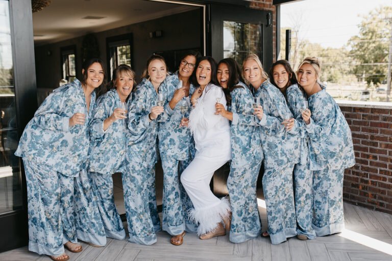 Bride and bridesmaids in matching blue floral robes on the patio while getting ready