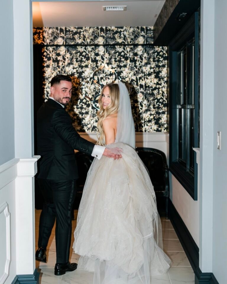 Bride and groom share a first look in a hallway with black-and-white floral wallpaper