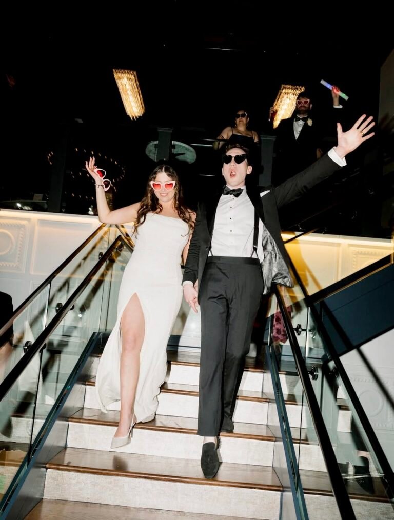 Bride and groom make a celebratory entrance down the glass staircase at Park Loft