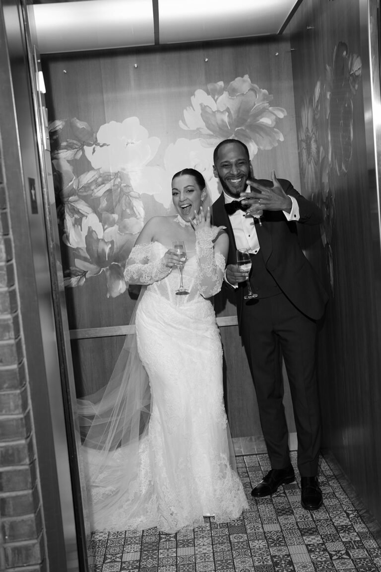 Black-and-white photo of a bride and groom celebrating in the doorway