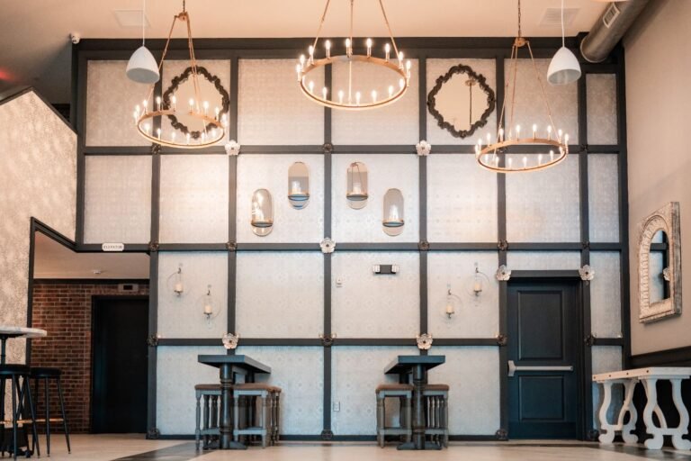 Park Loft entry lounge with black-framed wall panels, candle chandeliers and bar seating