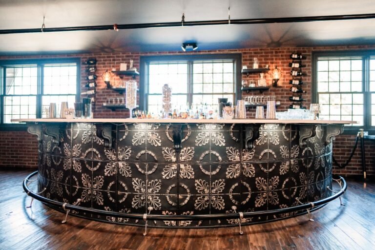 Park Loft's curved bar with an ornate tiled front, backed by brick and windows