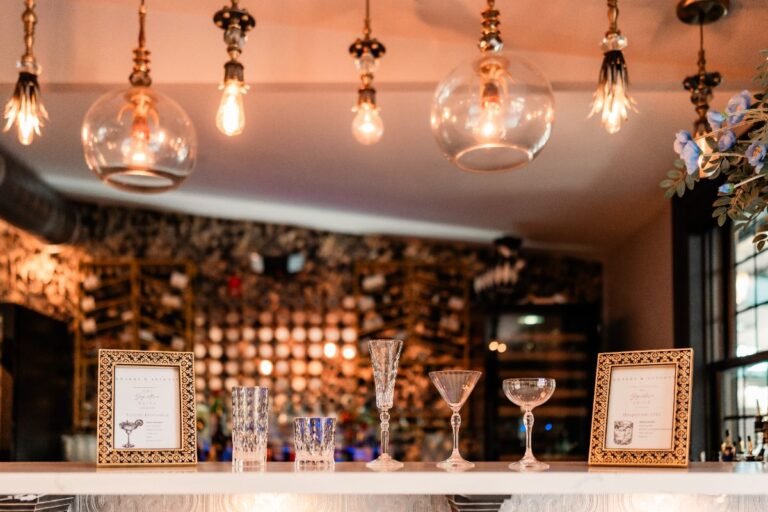 Park Loft bar with glass pendant lights, a mirrored back bar and cocktail glasses