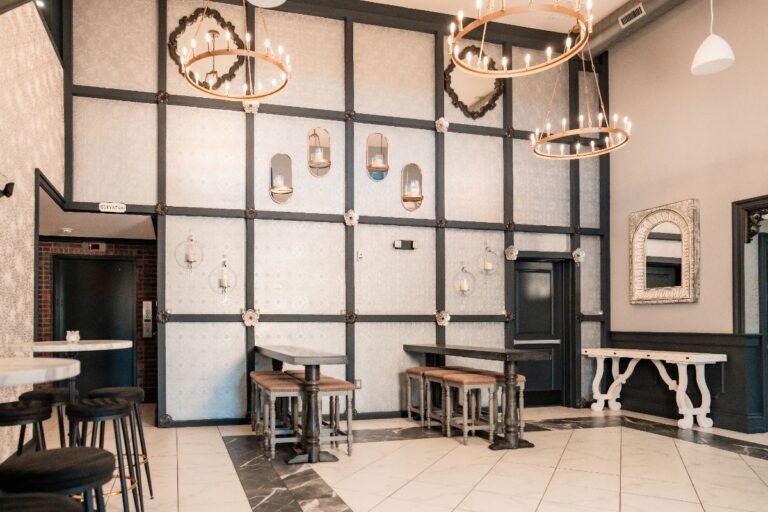 Park Loft entry lounge with black-framed wall panels, chandeliers and bar seating